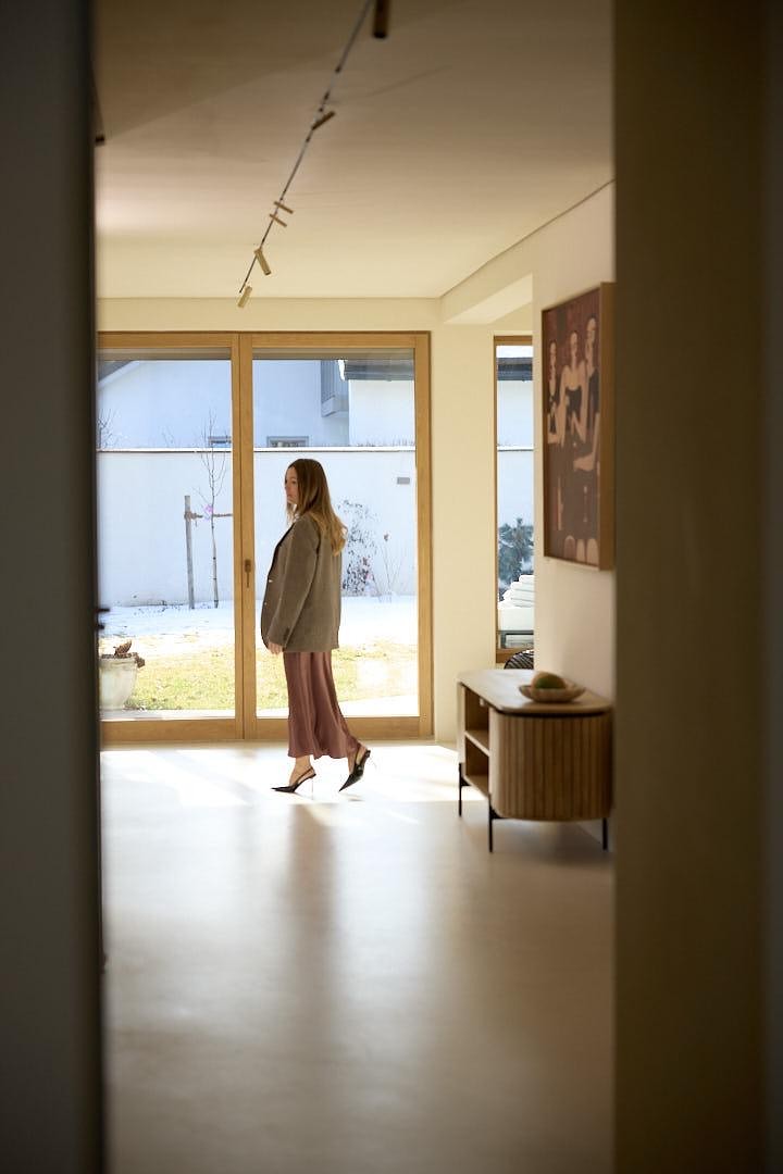 Raumhohe Fenstertür aus Holz-Alu in Eiche mit Blick in den Garten eines Hauses in Grünwald
