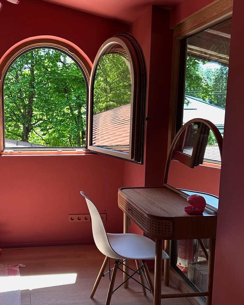 Geöffnetes Rundbogenfenster aus Holz-Alu in Eiche in einem Haus in Grünwald